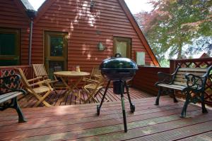 een grill op een terras met stoelen en een tafel bij Chalet Fiftynine in Deal