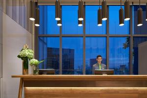 a man standing in front of a desk with two laptops at Courtyard by Marriott Singapore Novena in Singapore