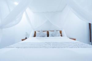 a white bed with white sheets and pillows at Arshaka Villa in Amed