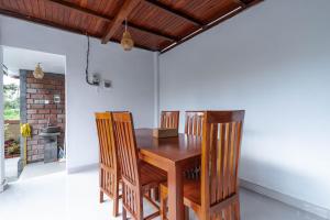 a dining room with a wooden table and chairs at Arshaka Villa in Amed