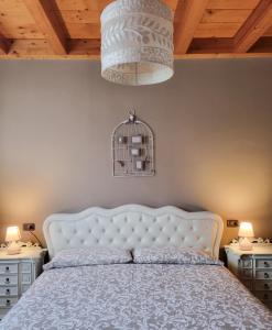 a bedroom with a white bed and two night stands at Loft Civico 12 in Pian Camuno