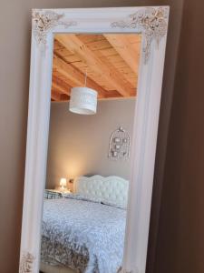 a mirror reflecting a bed in a bedroom at Loft Civico 12 in Pian Camuno