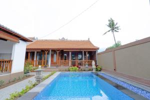a villa with a swimming pool in front of a house at Arshaka Villa in Amed