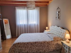 a bedroom with a white bed and a window at Loft Civico 12 in Pian Camuno