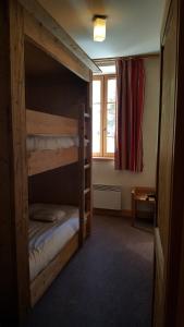 a room with two bunk beds and a window at Cortina - 11 - Appart grande terrasse - 8 pers in Les Deux Alpes