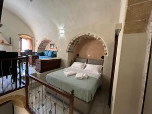 a bedroom with a bed in a room with an arch at MONOVASIA SUITES Tholos Hammam in Monemvasia