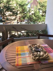 una mesa de madera con una cesta de rocas. en Casa Vacanze La Carezza en Montesilvano