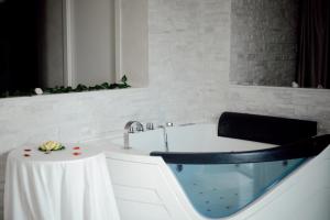 a bathroom with a bath tub with a sink at BlueBay Residence Resort in Taranto