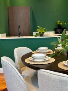 stół jadalny z krzesłami i zieloną ścianą w obiekcie شاليهــات داكــن w mieście Butainiyāt