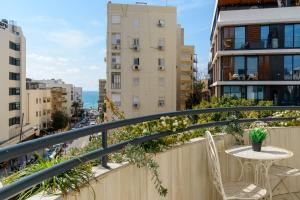 a balcony with a table and chairs and buildings at Bauhaus 2BR with Sea View & Balcony by FeelHome in Tel Aviv