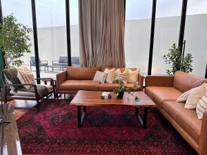 Sala de estar con sofás y mesa de centro en شاليهــات داكــن, en Butainiyāt