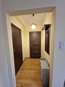 przedpokój pokoju z drzwiami i drewnianą podłogą w obiekcie Studio Jeziorak w Tarnobrzegu