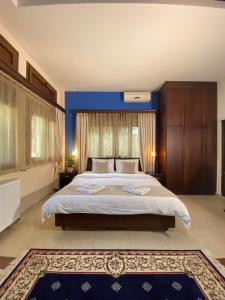 um quarto com uma cama grande e uma parede azul em Ευήλιον Σουίτες em Elati