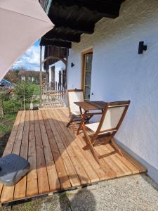 a wooden deck with two chairs and a table at Sonnseitn FW in Bad Heilbrunn