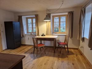 a kitchen with a table and chairs and windows at Sonnseitn FW in Bad Heilbrunn