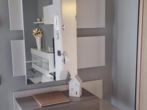 a bathroom with a mirror and a house on a shelf at Loft Civico 12 in Pian Camuno