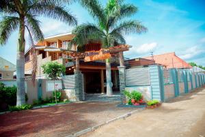 a house with palm trees in front of it at WILLOW INN in Dodoma