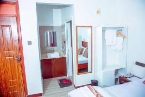 a bedroom with a bed and a sink and a mirror at WILLOW INN in Dodoma