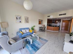 a living room with a blue couch and chairs at Vibrant,affordable Apt 5 Minutes From Metro in Dubai