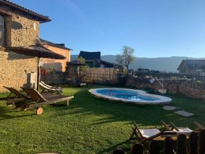 a yard with a pool and chairs and a building at Regalate Paz in Arguis