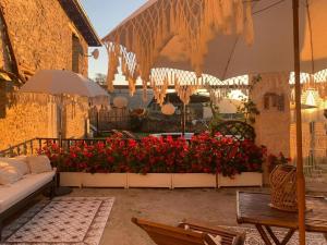 a patio with red flowers and an umbrella at Regalate Paz in Arguis