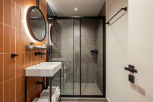 a bathroom with a shower and a sink and a mirror at Bonnie Athens by Nin&Bau in Athens