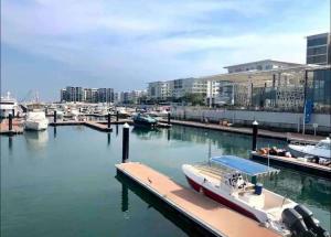a boat docked at a dock in a marina at Beachfront 2BHK apartment at Al Mouj in Seeb
