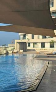錫卜的住宿－Beachfront 2BHK apartment at Al Mouj，享有大楼内游泳池的景致
