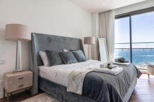 una camera da letto con un letto grande con una grande finestra di Del Mar Beachfront 'C' 2 Bedroom Residence a Limassol