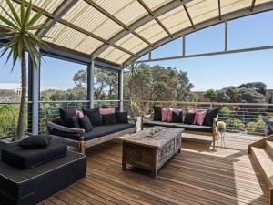 a patio with couches and a table on a deck at Diamond View in Sorrento