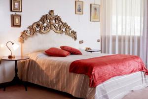 een slaapkamer met een groot bed met rode kussens bij [LUXURY]・VILLA ☆☆☆☆☆・Pool, Sauna and Park in Sedriano