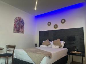 ein Schlafzimmer mit einem großen Bett mit violetter Beleuchtung in der Unterkunft 40 40 Accommodation in Matola