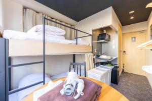 a room with two bunk beds and a table at HOTEL HARE BARE 3min walk from Kiba Station in Tokyo