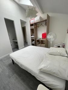 Schlafzimmer mit einem großen weißen Bett und einem Schreibtisch in der Unterkunft Duplex 4 pièces, 3 chambres in Ivry-sur-Seine