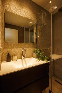 a bathroom with a sink and a mirror at Herzl Luxury Hotel By Nimizz in Tel Aviv