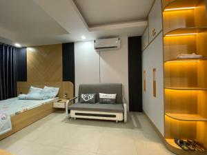 um quarto com uma cama e uma cadeira em Căn hộ studio tầng 16 chung cư Sophia Center em Ấp Rạch Mẹo