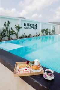 una bandeja de comida en una mesa junto a una piscina en มาริลิน พูลวิลล่า ขนอม, 