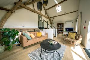 a living room with a couch and a table at B&B De Woestijn in Roosdaal