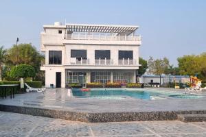 a building with a swimming pool in front of a house at Rupis Resort in Dabok