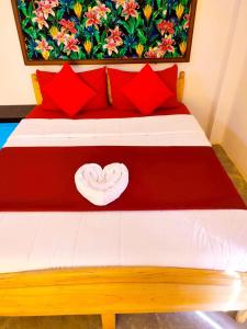 a red and white bed with red pillows at Hanthana SK Paradise in Gampola
