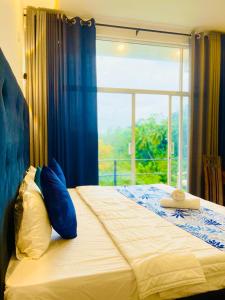a bedroom with a bed with a large window at Hanthana SK Paradise in Gampola
