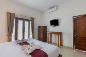 1 dormitorio con 1 cama con toallas en Gapul pinpilinPauxa, en Nusa Penida