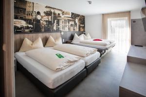 three beds are lined up in a room at FairSleep AVIA Motel Zwettl in Zwettl Stadt