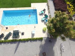 an overhead view of a swimming pool with chairs and palm trees at Casa Cachada in Braga