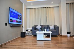 a living room with a couch and a table and a tv at ESSENCE GRANDEUR in Guwahati