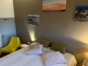 a bedroom with a bed and a yellow chair at A L'OMBRE DE LA TOUR EIFFEL AU BORD DE LA SEINE in Paris