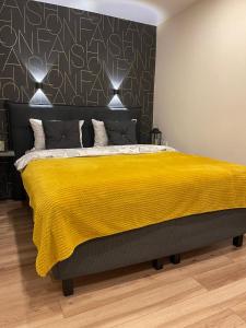 a bedroom with a large bed with a yellow blanket at Fashion Apartment in Narva