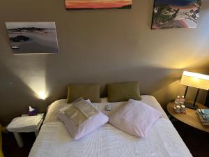1 dormitorio con 1 cama con sábanas y almohadas blancas en A L'OMBRE DE LA TOUR EIFFEL AU BORD DE LA SEINE, en París