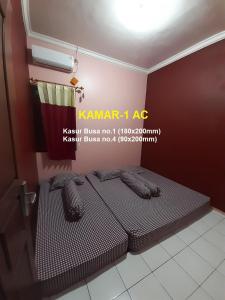 1 cama en una habitación con un cartel en la pared en Homestay Cendana Candi 1 Kudus en Kudus