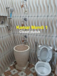 a bathroom with a toilet and a sink in it at Homestay Cendana Candi 1 Kudus in Kudus